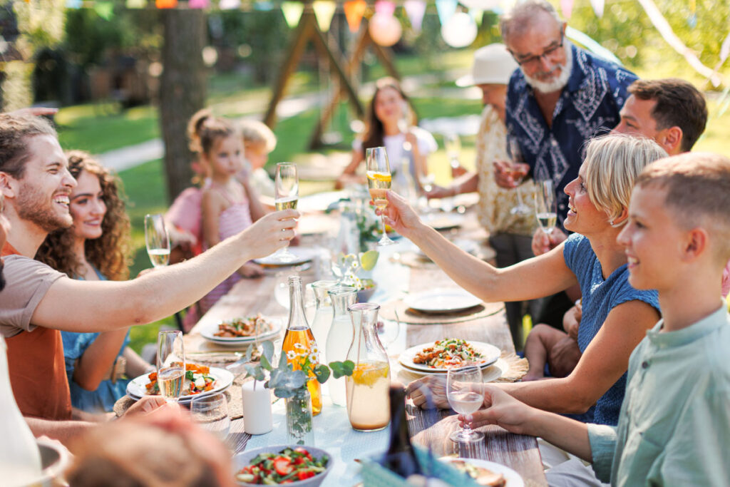 Gäste genießen gemeinsames Essen bei einer Gartenfeier mit professionellem Gyros-Catering für private Feiern und Events